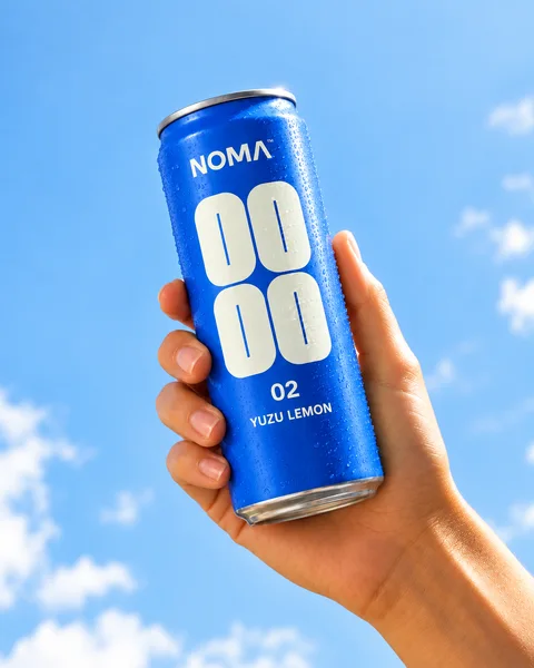 Cobalt-blue NOMA can held against a summer sky